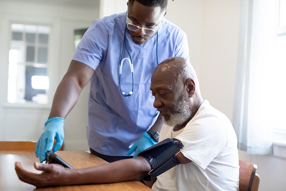 doctor checking blood pressure of old man