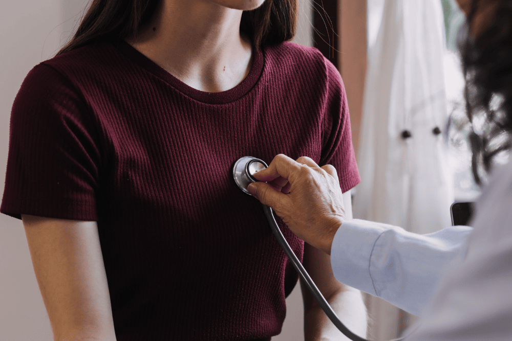 Doctor using stethoscope on patient