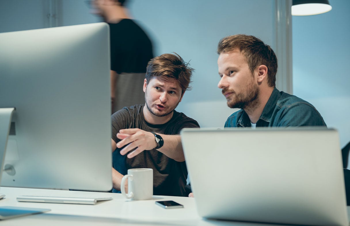two-men-talking-at-a-screen