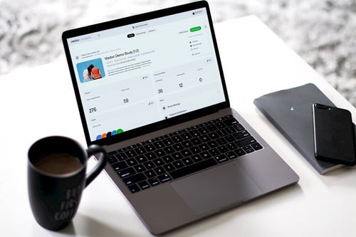 A computer displaying the Viedoc Designer interface, placed on a desk, representing a workspace setup.