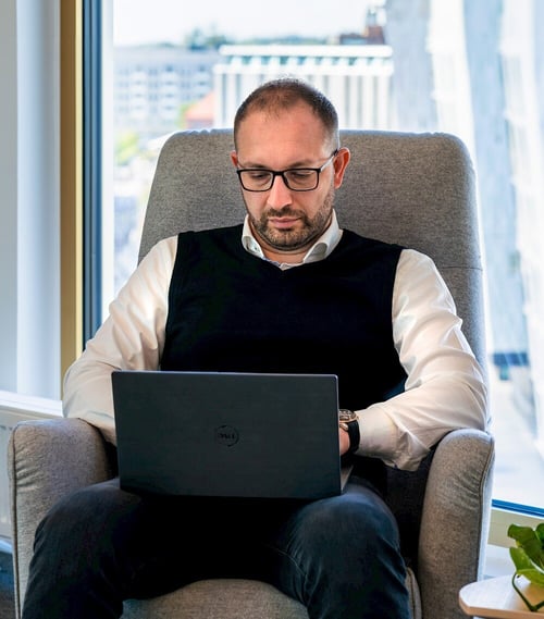 Majd Mirza, Chief Innovation Officer at Viedoc, working on his laptop, symbolizing the integration of data pipelines and data lakes for efficient extraction, transformation, and storage of clinical trial data.