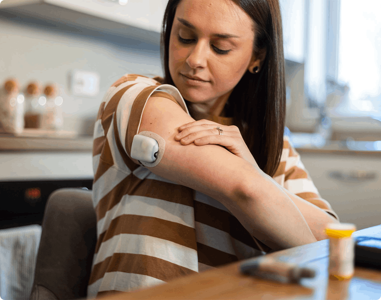 woman looking at medical device on her arm